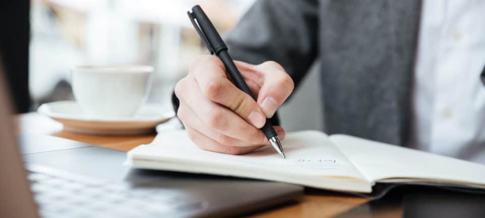 https://www.kara.fr/wp-content/uploads/2022/01/cropped-image-of-businessman-sitting-by-the-table-in-cafe-with-laptop-computer-and-writing-something-1-962x433.jpg